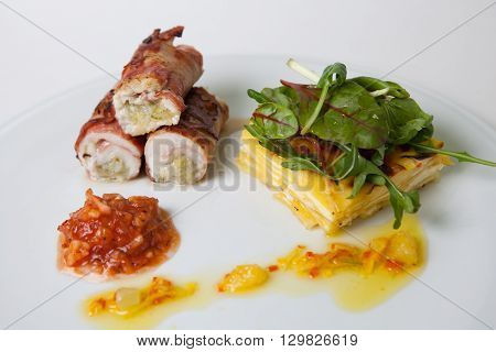 Stuffed meat rolls with garnish and sauce