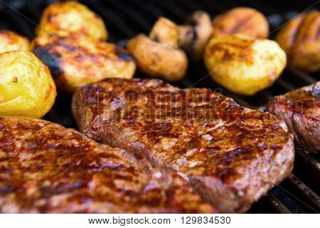 delicious grilled rump steak with mushrooms and potatoes on barbecue