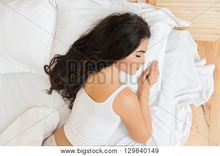 Brunette girl sleeps in the white  bedroom