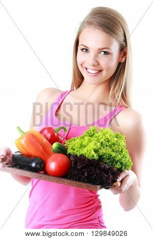 Isolated young woman holding basket of vegetables on light backg