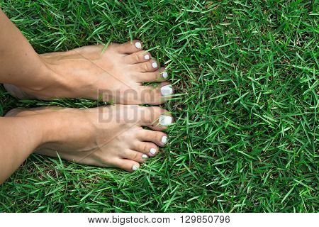 Barefoot girl on the soft summer grass.