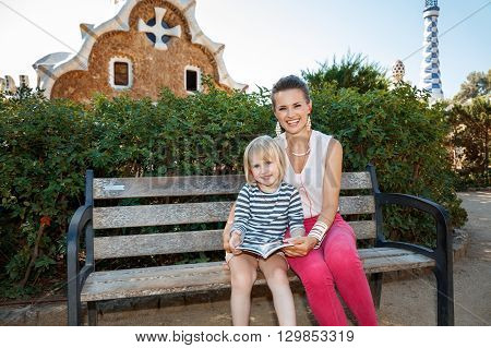 Happy Mother And Daughter Listening Audioguide In Park Guell