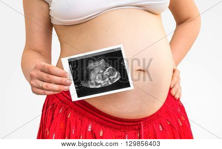 Belly of a pregnant woman and ultrasound with baby isolated on white background