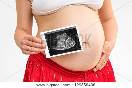 Belly of a pregnant woman and ultrasound with baby isolated on white background