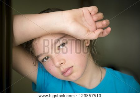 A sad little girl is standing on his doorstep