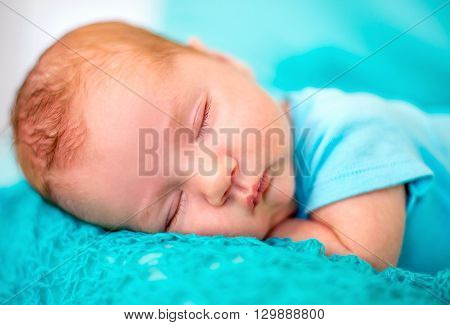 The baby sleeps on the tummy pens under head