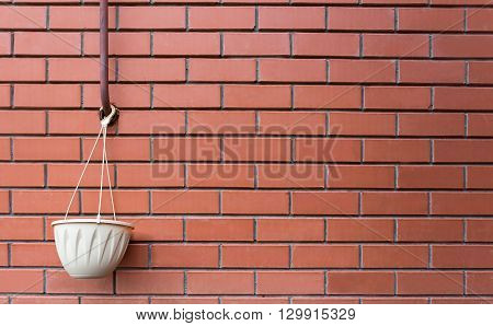 pot hanging on a brick wall background closeup