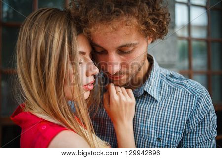 The curly-haired guy with the red-haired girl with freckles on the background of fabulous scenery of city and nature. Lovely couple of lovers on a walk in the city and nature. Tenderness emotion