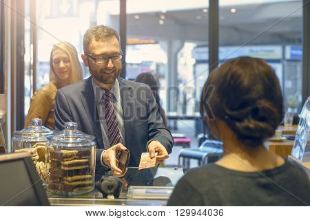 Male Customer Handing Over A Banknote