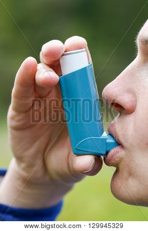 Asthma patient inhaling medication for treating shortness of breath and wheezing. Chronic disease control allergy induced asthma remedy and chronic pulmonary disease concept.