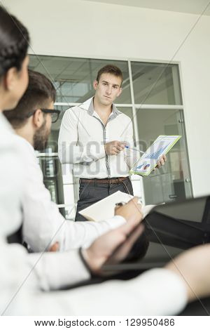 Young successful business man presenting the results of the latest project he has been workng on