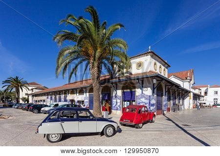 Santarem, Portugal. September 10, 2015: The Farmers Market of Santarem with two classic European cars, the Citroen Dyane (gray) and the Citroen 2cv (red) parked in front of it.
