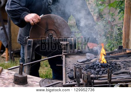 Blacksmith working on metal medieval fire iron hammer work