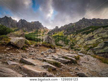 Rocky Hiking Trail with Sun Shining From Behind the Peaks in Mountains Under Dramatic Sky. Mlynicka Valley High Tatra Slovakia.