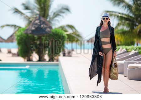 Young beautiful woman enjoying the luxurious quiet swimmingpool