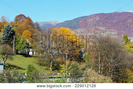 Autumn Carpathian Mountains Landscape With Multicolored Trees And Mountain Village Outskirts On Slop