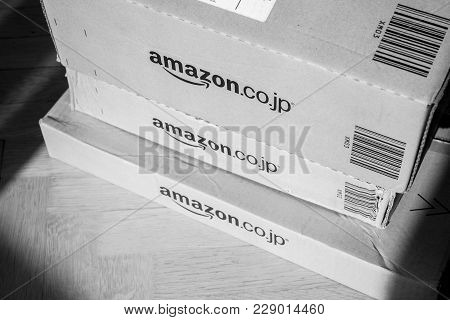 Paris, France - Feb 21, 2018: Black And White Image Of Amazon Prime Japan Boxes Stack On Wooden Bacg