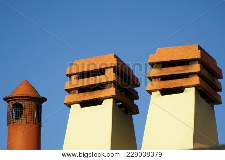 Stone Square Chimney On The Roof In Sunny Weather