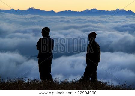 People Contemplating A Sea Of Clouds