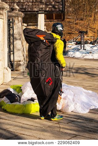 Boy With Paragliding Technical Clothing And Helmet Landed