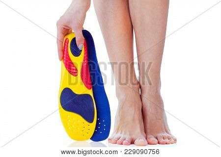 Orthopedic Insole In The Hand And Female Feet Stand On Tiptoe