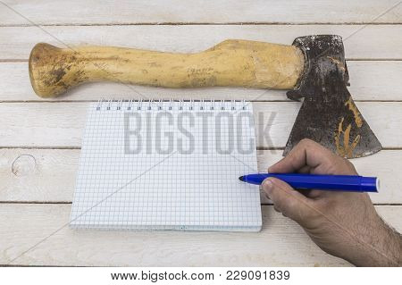 Hand Writing On Blank Notepad Near The Ax. Suicide Notes