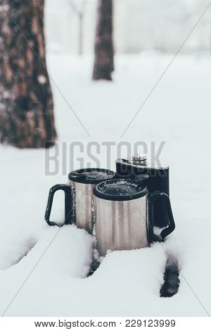 Close Up View Of Thermocups And Flask In Snow On Winter Day In Forest