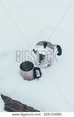Close Up View Of Cup And Coffee Maker In Snow