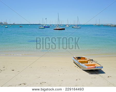 Rowboat On The Beach With Yachts Background