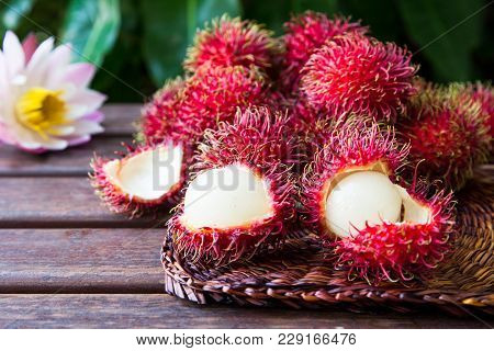 Fresh Ripe Rambutans On Wooden Background. Delicious Rambutan Sweet Fruit