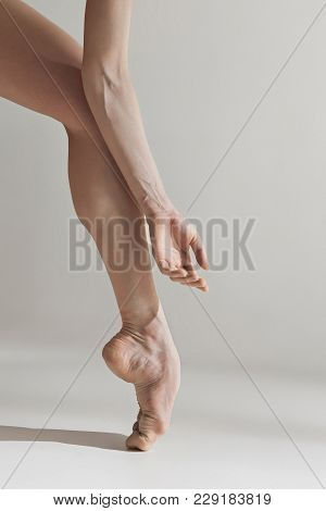 Close-up Ballerina's Legs On The White Floor