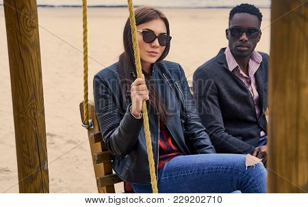 Caucasian Female And Black Mail On A Date Having Fun On A Wooden Flip Flap.