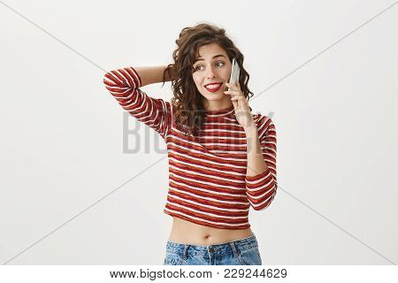 Indoor Shot Of Hesitating Adult Woman With Stylish Appearance Scratching Back Of Head While Talking 