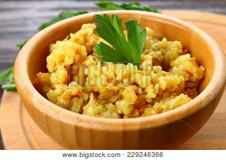 Rice Pilaf With Chicken, Spices And Parsley In A Bowl On A Wooden Table