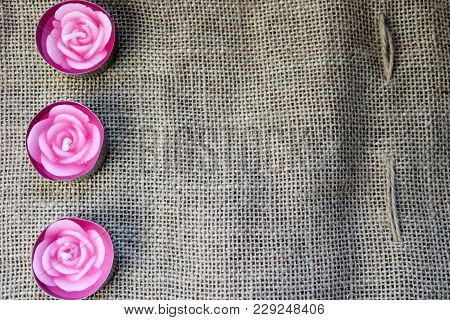 Three Pink Wax Beautiful Candles In The Form Of Rose Flowers With An Unflavored Wick Against The Bac
