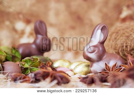 Easter Bunnies, Made Of White And Milk Chocolate Against A Brown Background.