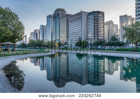 Abu Dhabi High Rise Along The Corniche Boulevard Near The Beach Park And Its Reflaction In The Pond