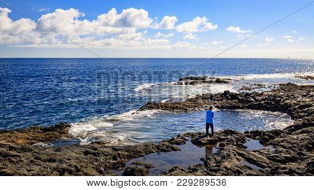 Angler on El Bufadero, rocky seashore on Gran Canaria island, Spain.