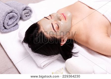 Spa Facial Mask Application. Beautiful Relaxed Woman Having Clay Face Mask In The Spa. Beautiful Tre