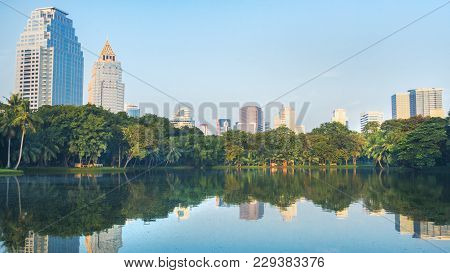 Modern Bangkok Building City With Reflection Of Water And Urban Garden Park Green Space Landscape An