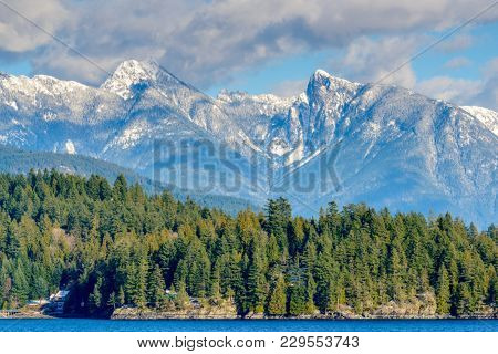 Fantastic view over ocean, snow mountain and rocks at Sechelt inlet in Vancouver, Canada.