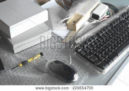 Messy Table Top With Keyboard, Tools And Packing Film, Concept Of Office Removal