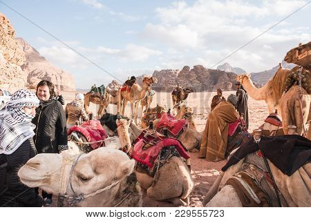 Wadi Rum, Jordan - December, 25, 2017: Tourists And Bedouins Near Camals In Wadi Rum Desert In Jorda