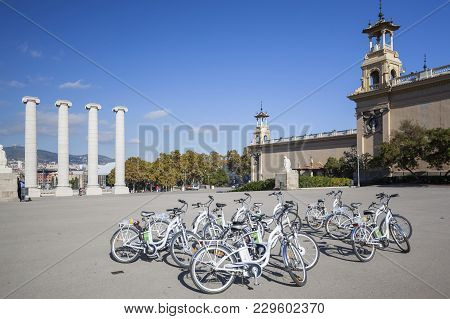 Barcelona,spain-november 7,2013: Group Of Rental Bikes And Four Columns, Les Quatre Columnes Or Colu