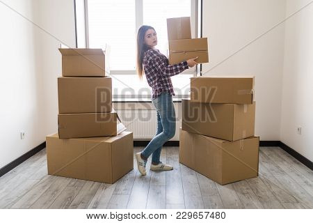 Young Woman Is Transporting A Filled Cardboard In New Apparment
