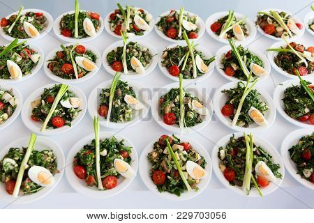 Many Plates Of Green Vegetable Salad On White Table