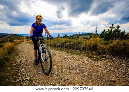 Mountain biking women riding on bike in summer mountains forest landscape. Woman cycling MTB flow trail track. Outdoor sport activity.