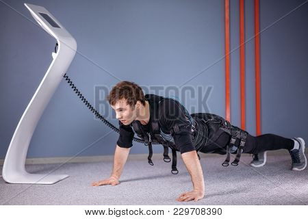 Man In Electrical Muscular Stimulation Suits Doing Plank Exercise. Ems. Workout.