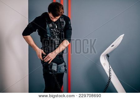 Fit Man Preparing For Training And Connecting Cables Of Ems Suit