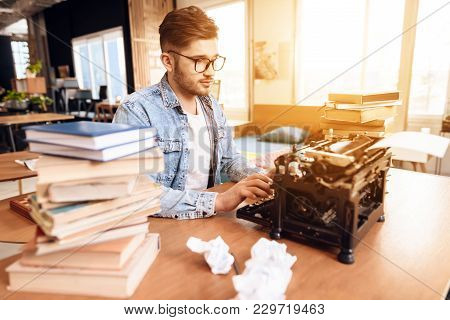 Freelancer Man In Jeans Shirt Typing At Old Typewritter Sitting At Desk.
